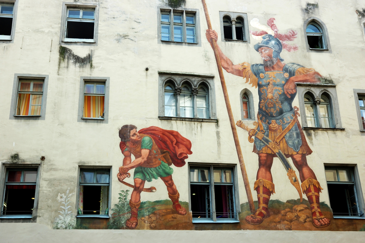 An image of a mural on the side of a building showing David and Goliath
